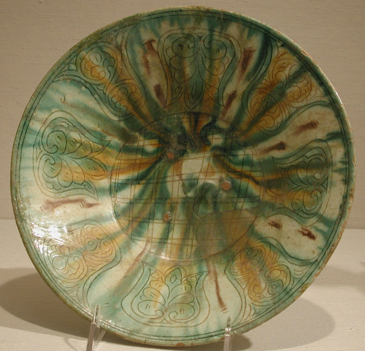 Sgraffito decorated ceramic bowl with green, yellow, and brown glaze