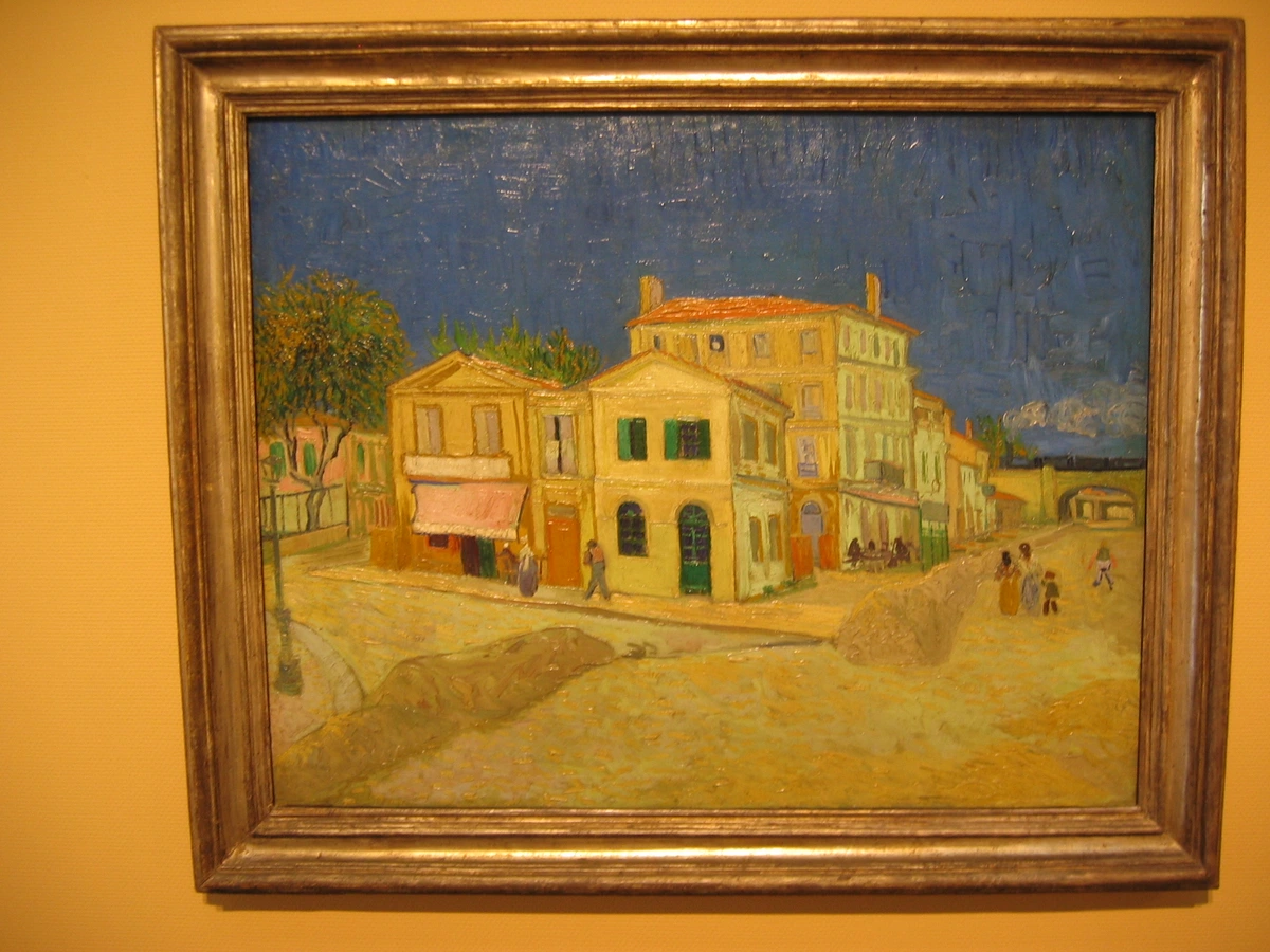 Vincent van Gogh's painting 'The Yellow House' depicting a street scene with buildings and people.